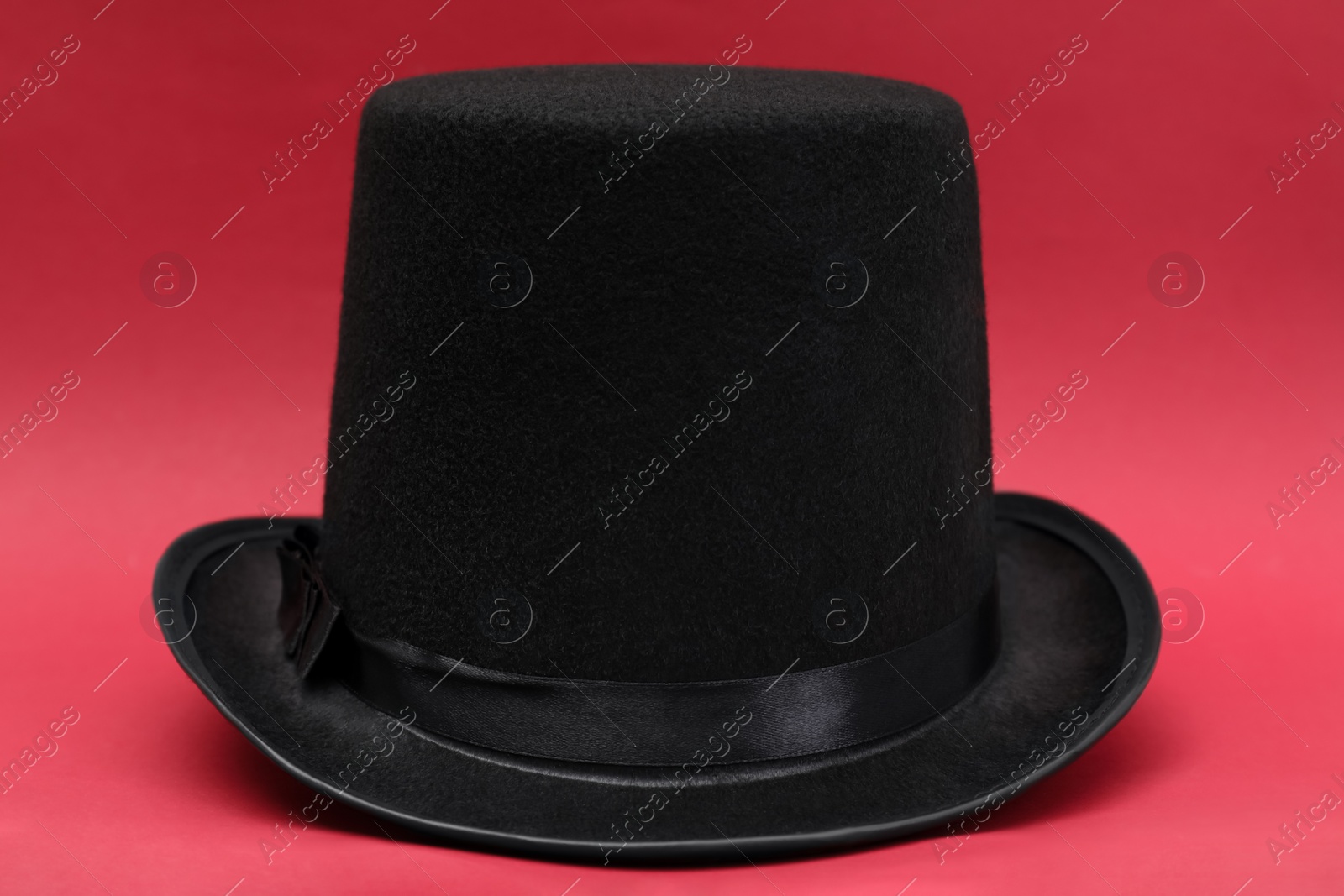 Photo of One magician top hat on red background