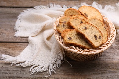 Photo of Sweet hard chuck crackers with raisins in wicker basket on wooden table. Space for text