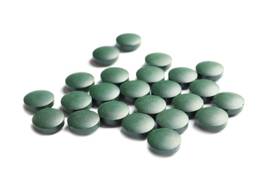 Photo of Heap of spirulina tablets on white background
