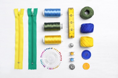 Photo of Flat lay composition with sewing threads and accessories on wooden background