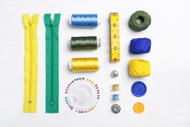 Flat lay composition with sewing threads and accessories on wooden background