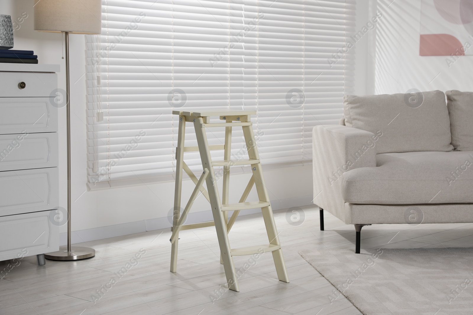 Photo of Folding ladder on wooden floor at home