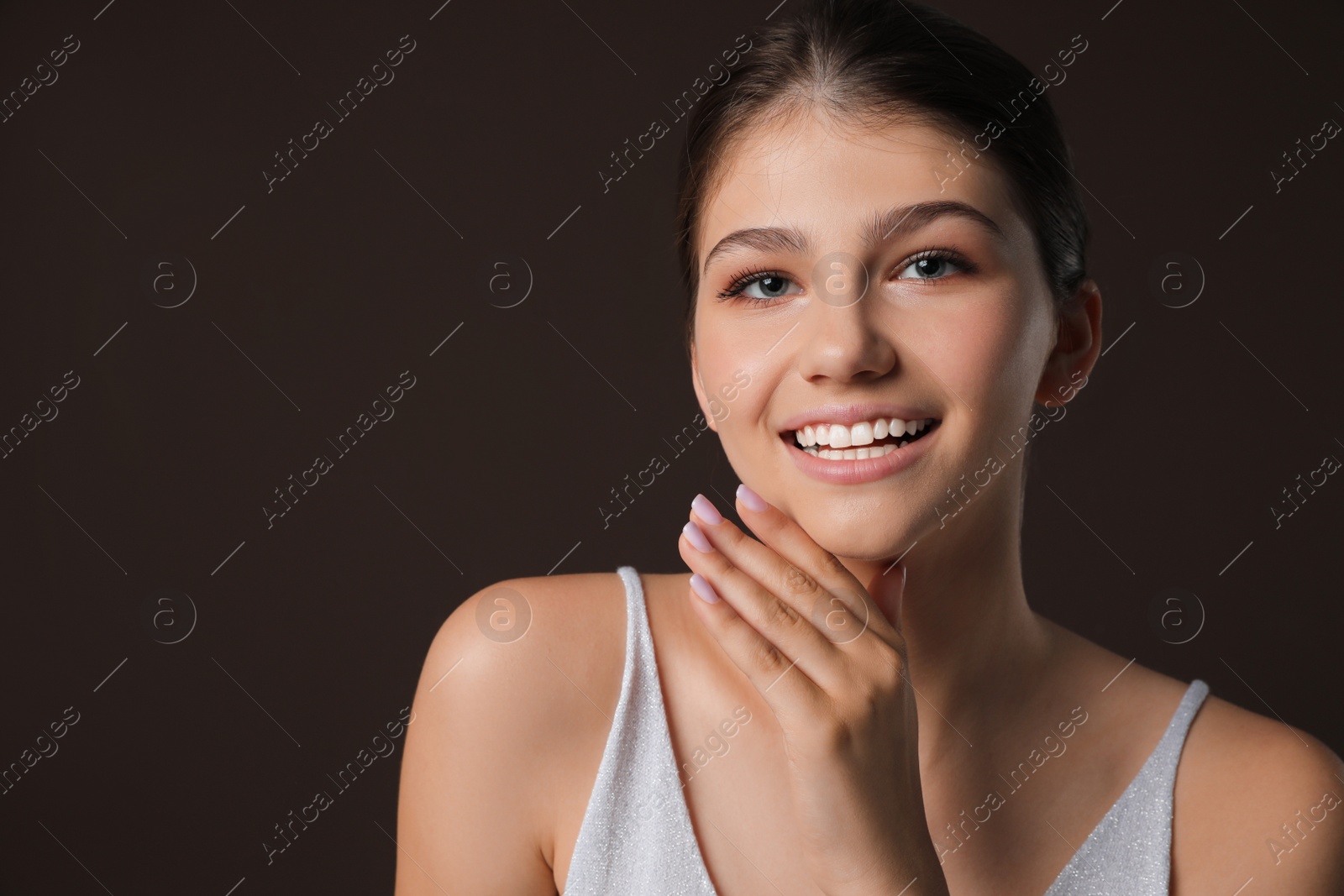 Photo of Portrait of pretty girl on brown background. Beautiful face with perfect smooth skin