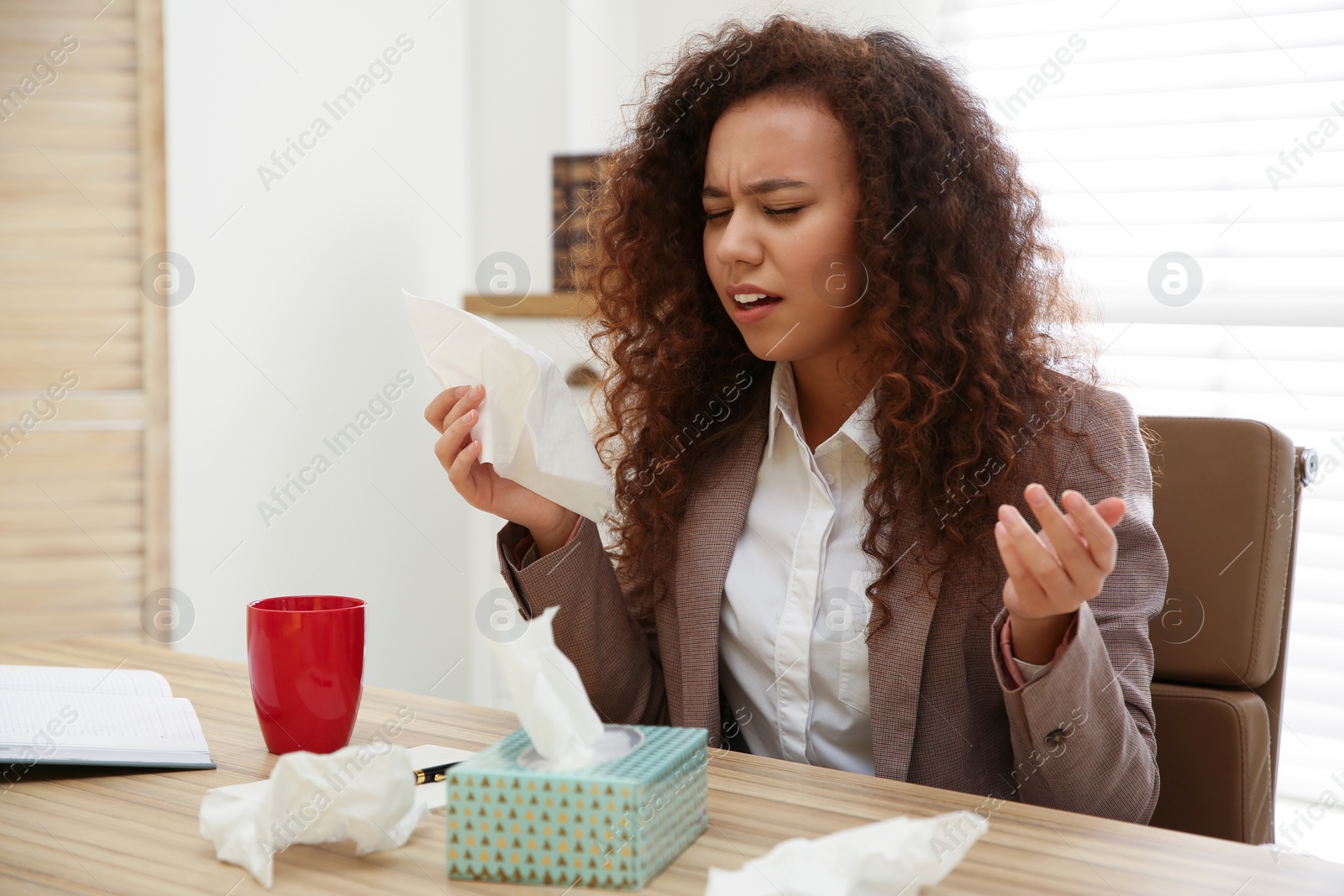 Photo of Sick African-American woman at workplace. Influenza virus