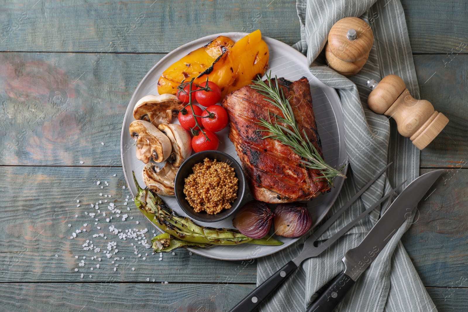 Photo of Delicious grilled meat and vegetables served on wooden table, flat lay