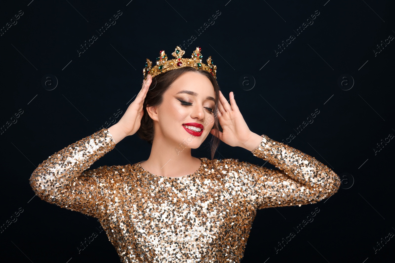 Photo of Beautiful young woman wearing luxurious crown on black background