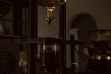 Photo of Professional vacuum coffee maker in cafe, closeup. Space for text