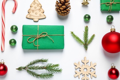 Christmas tree branches and festive decoration on white background, top view