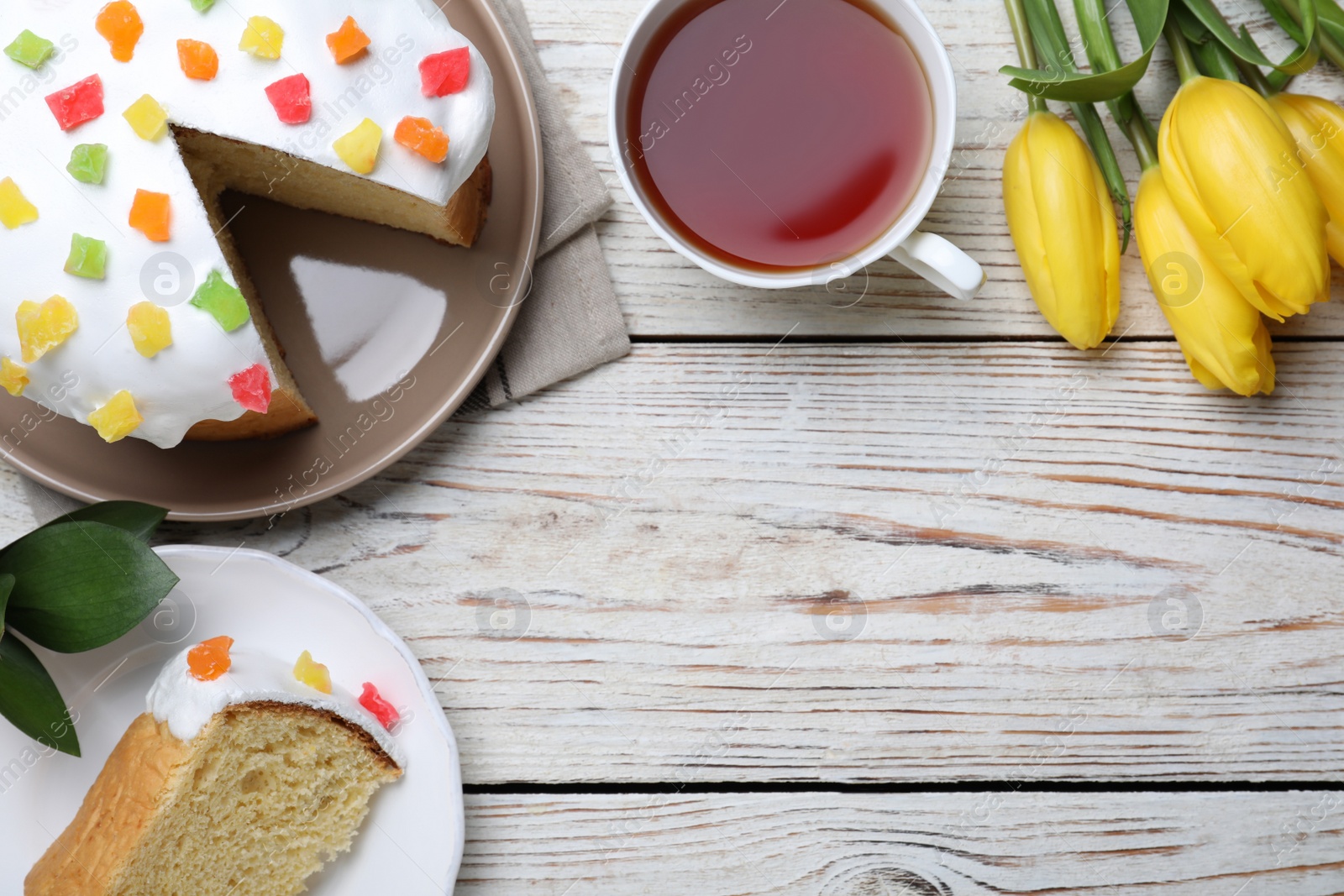 Photo of Flat lay composition with Easter cake on white wooden table. Space for text