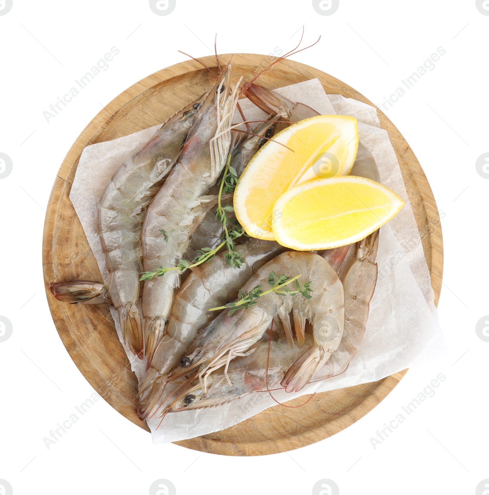 Photo of Wooden plate with raw shrimps, lemon slices and thyme isolated on white, top view