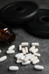 Photo of Bottle and amino acid pills on grey table