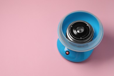 Photo of Portable candy cotton machine on pink background, above view. Space for text
