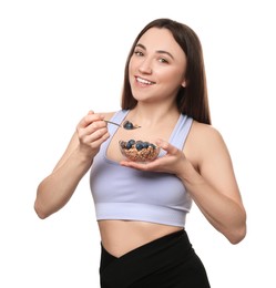 Happy woman eating tasty granola with fresh berries on white background