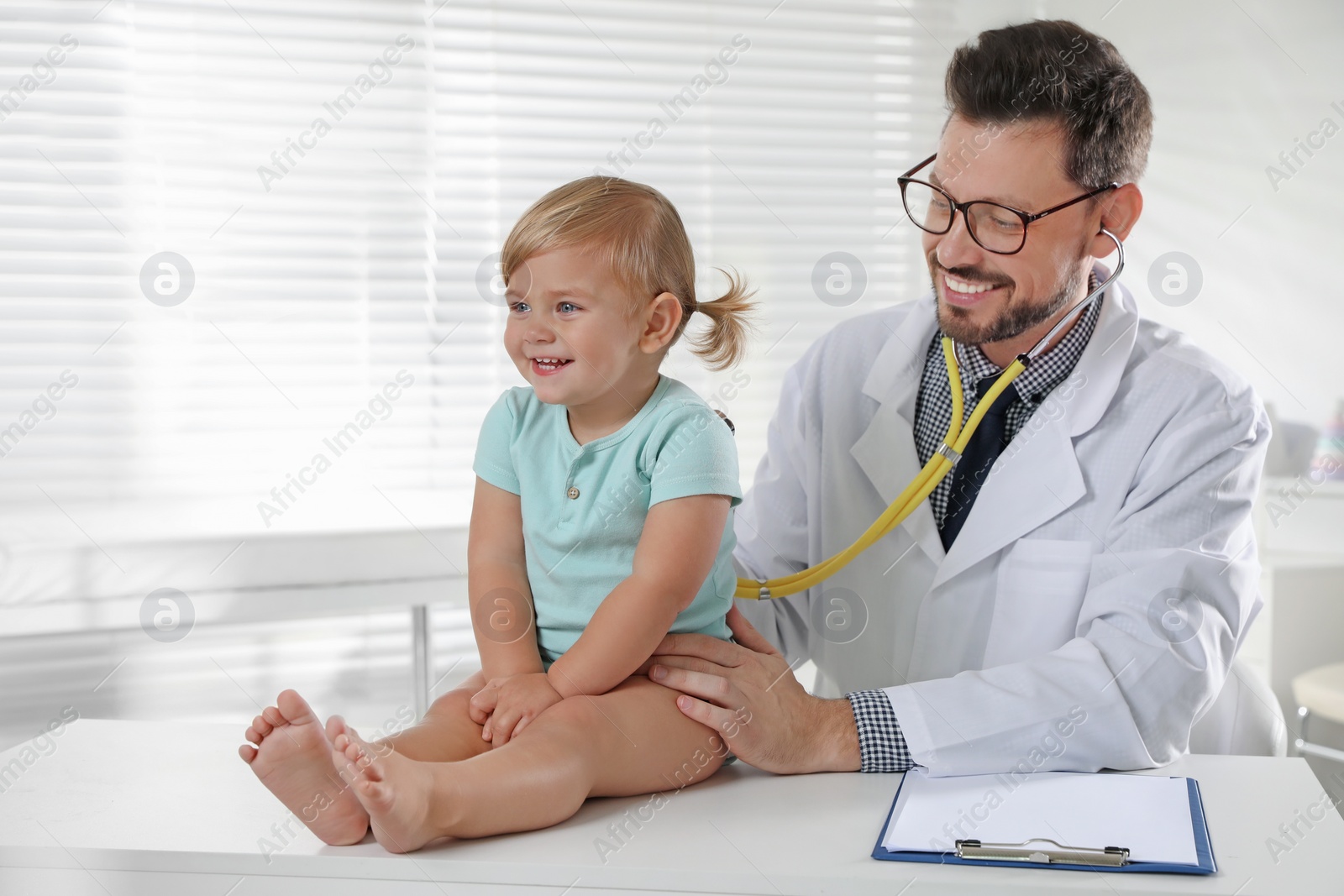 Photo of Pediatrician examining baby with stethoscope in clinic