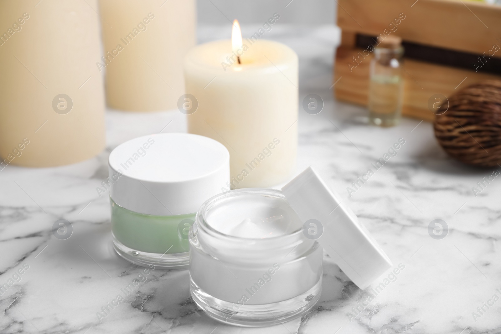 Photo of Jars of facial cream on white marble table