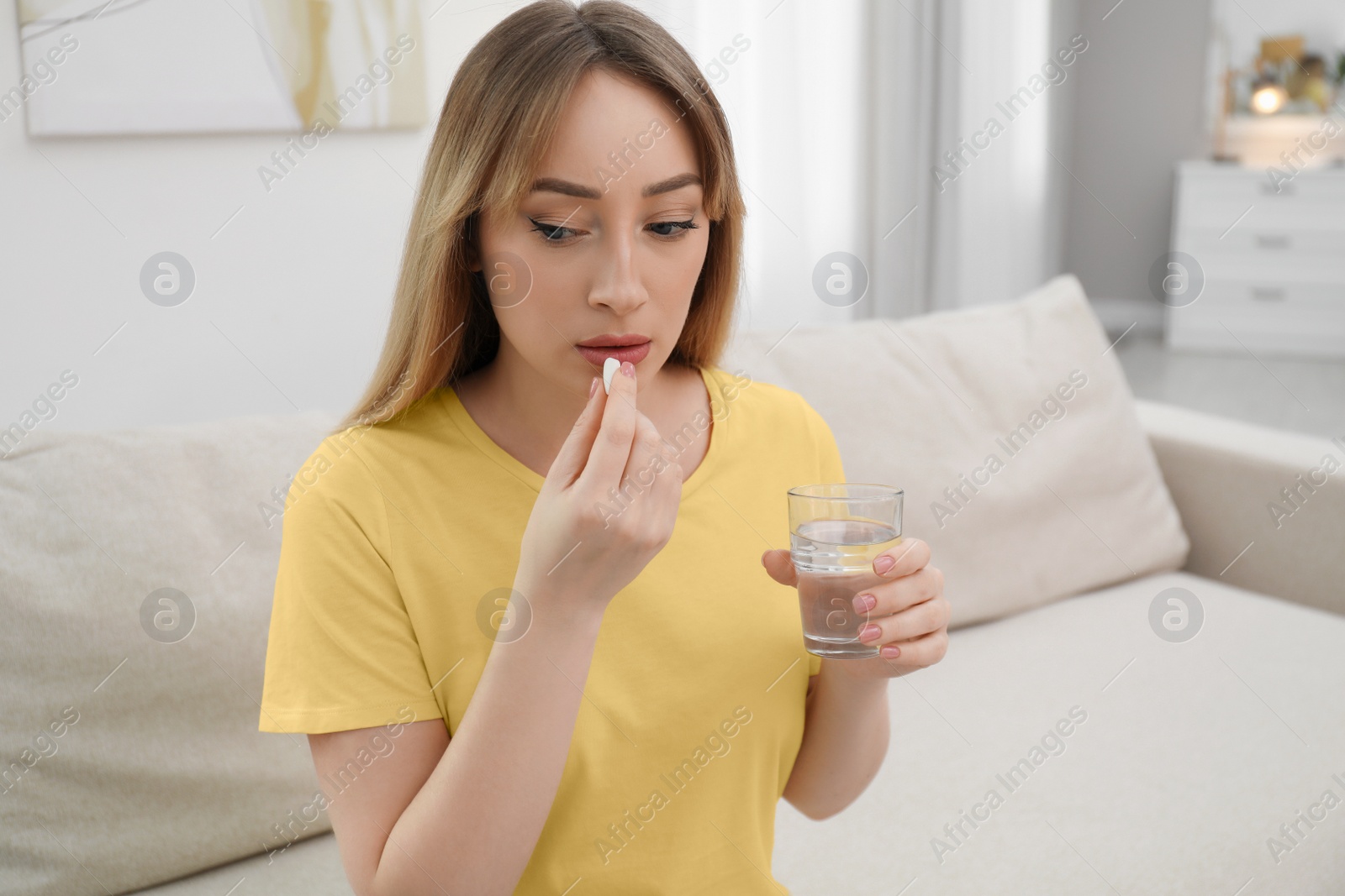 Photo of Young woman taking abortion pill at home