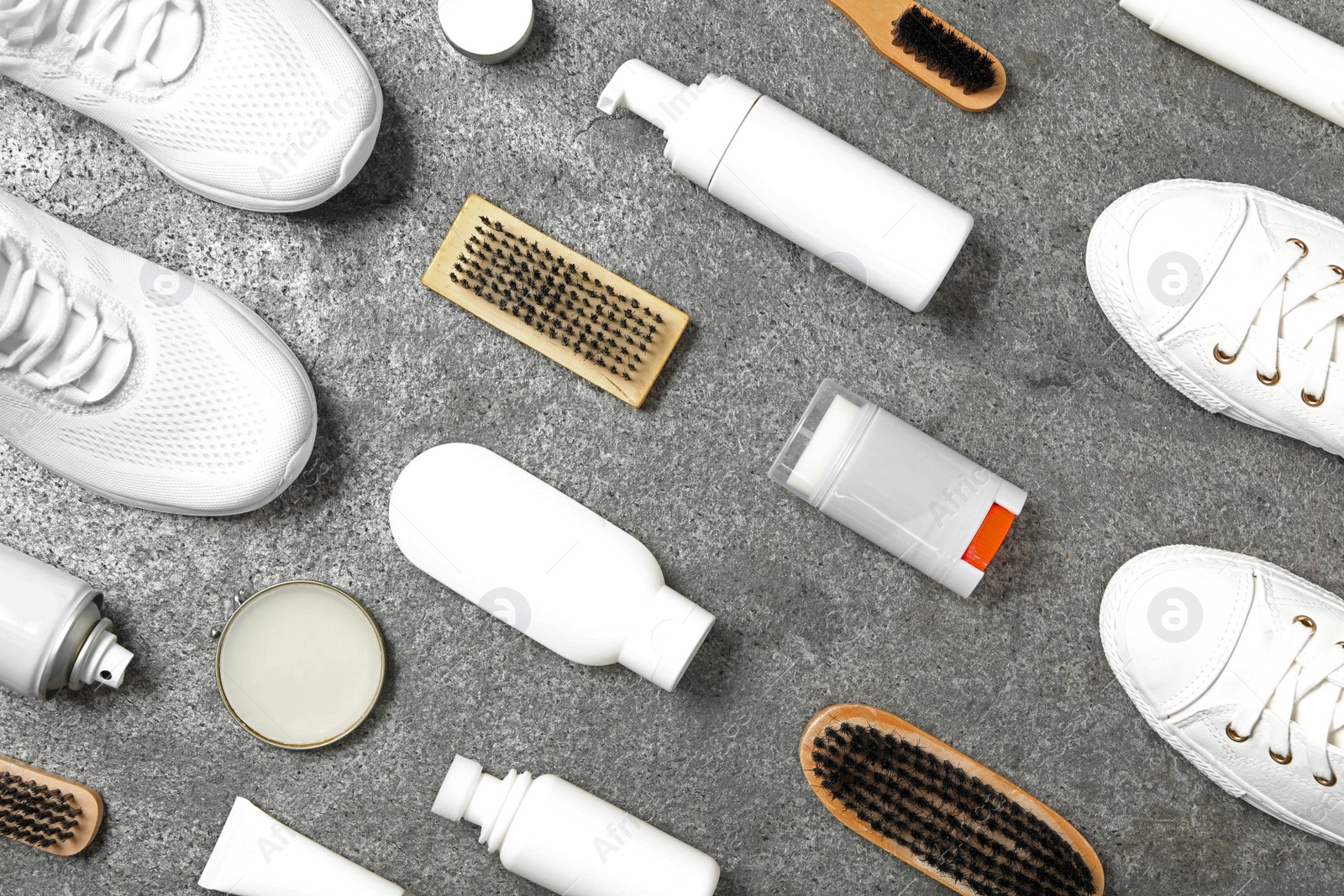 Photo of Flat lay composition with stylish footwear and shoe care accessories on grey background