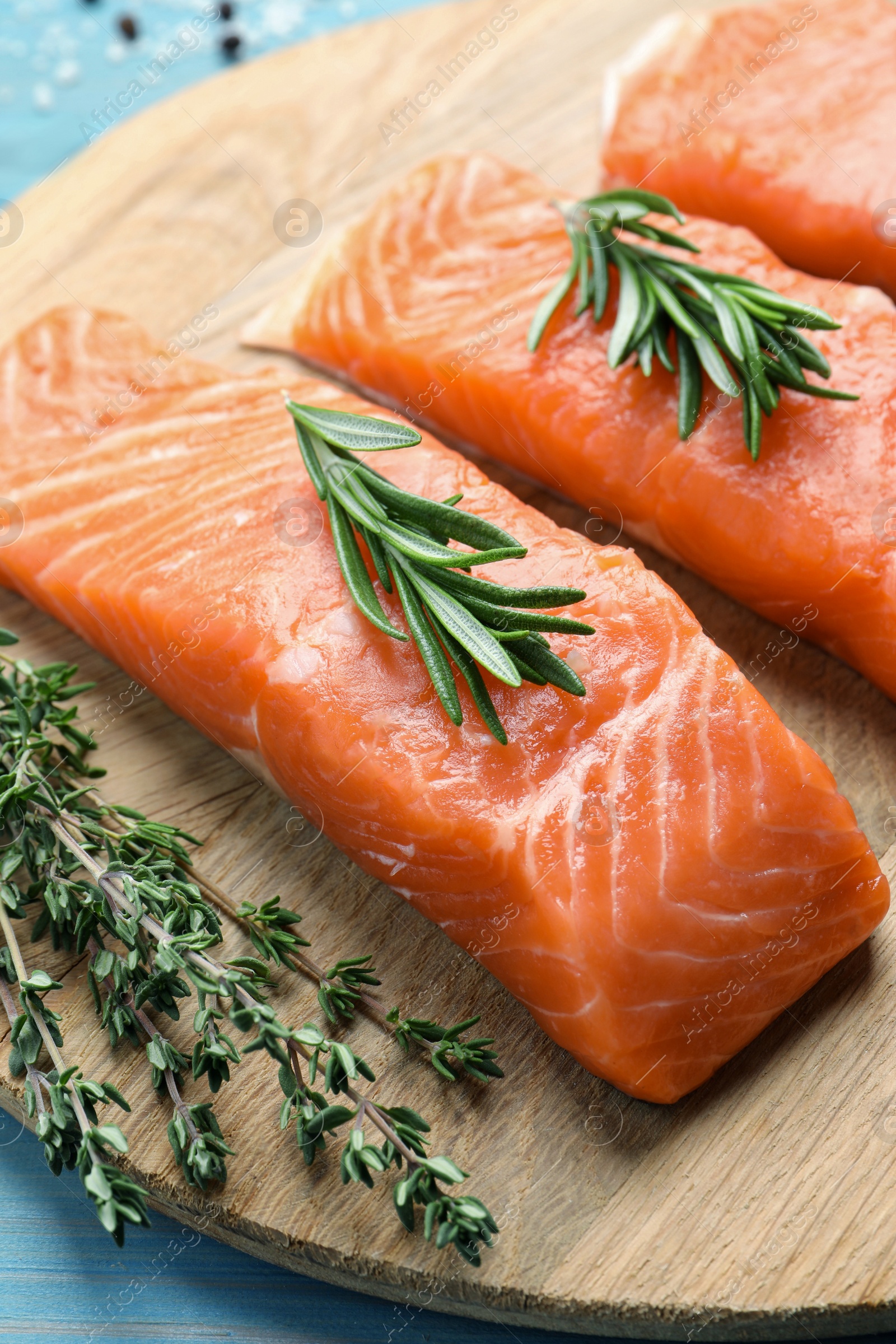 Photo of Fresh raw salmon and ingredients for marinade on light blue wooden table, closeup