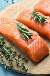Photo of Fresh raw salmon and ingredients for marinade on light blue wooden table, closeup