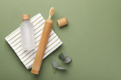 Flat lay composition with bamboo toothbrush on green background, space for text