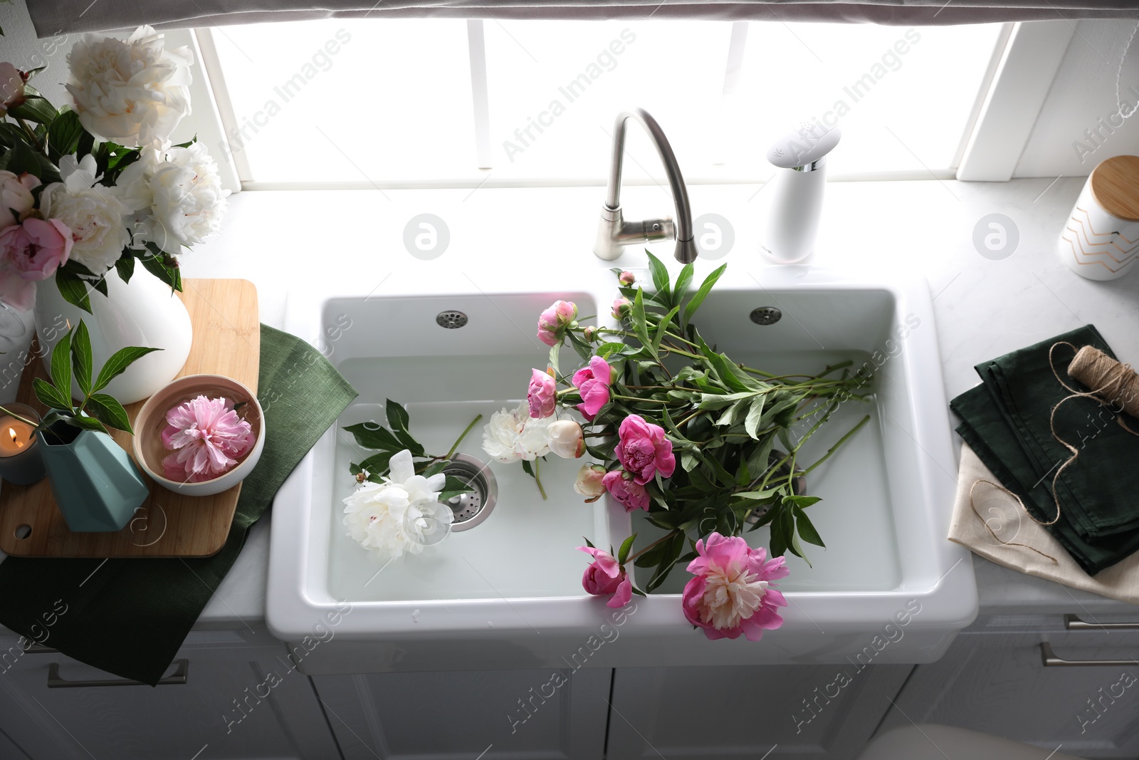 Photo of Beautiful kitchen counter design with fresh peonies, above view