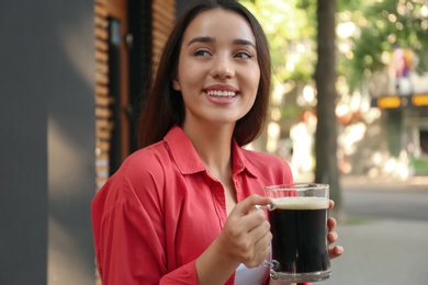 Beautiful woman with cold kvass outdoors. Traditional Russian summer drink