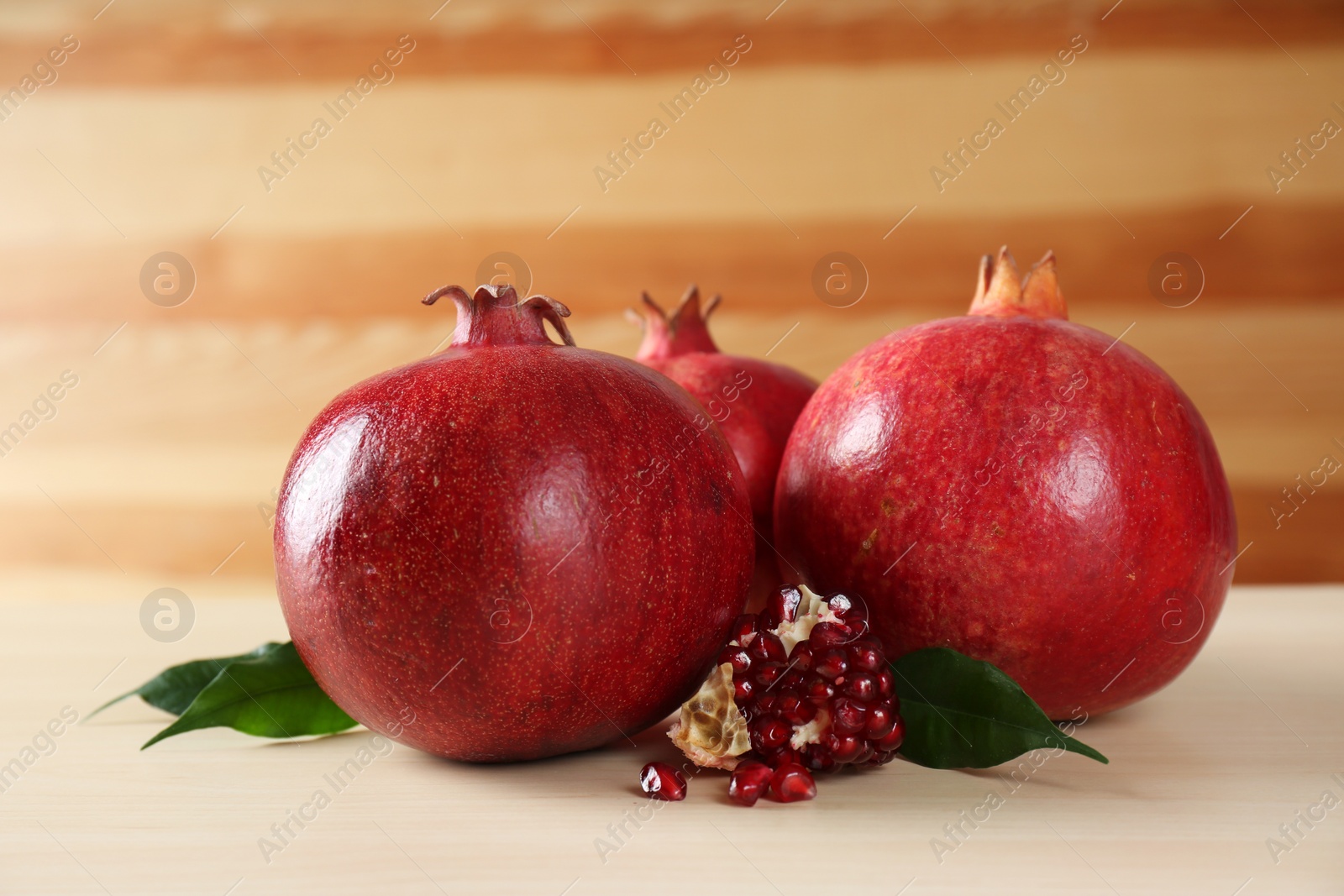 Photo of Ripe pomegranates on wooden table. Tasty fruits