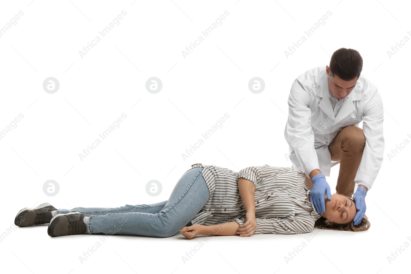 Photo of Doctor in uniform practicing first aid on woman against white background