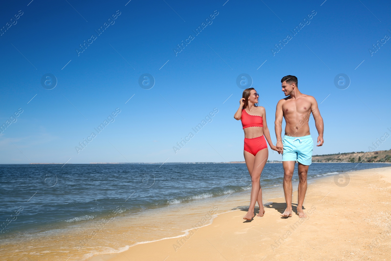 Photo of Woman in bikini and her boyfriend on beach, space for text. Happy couple