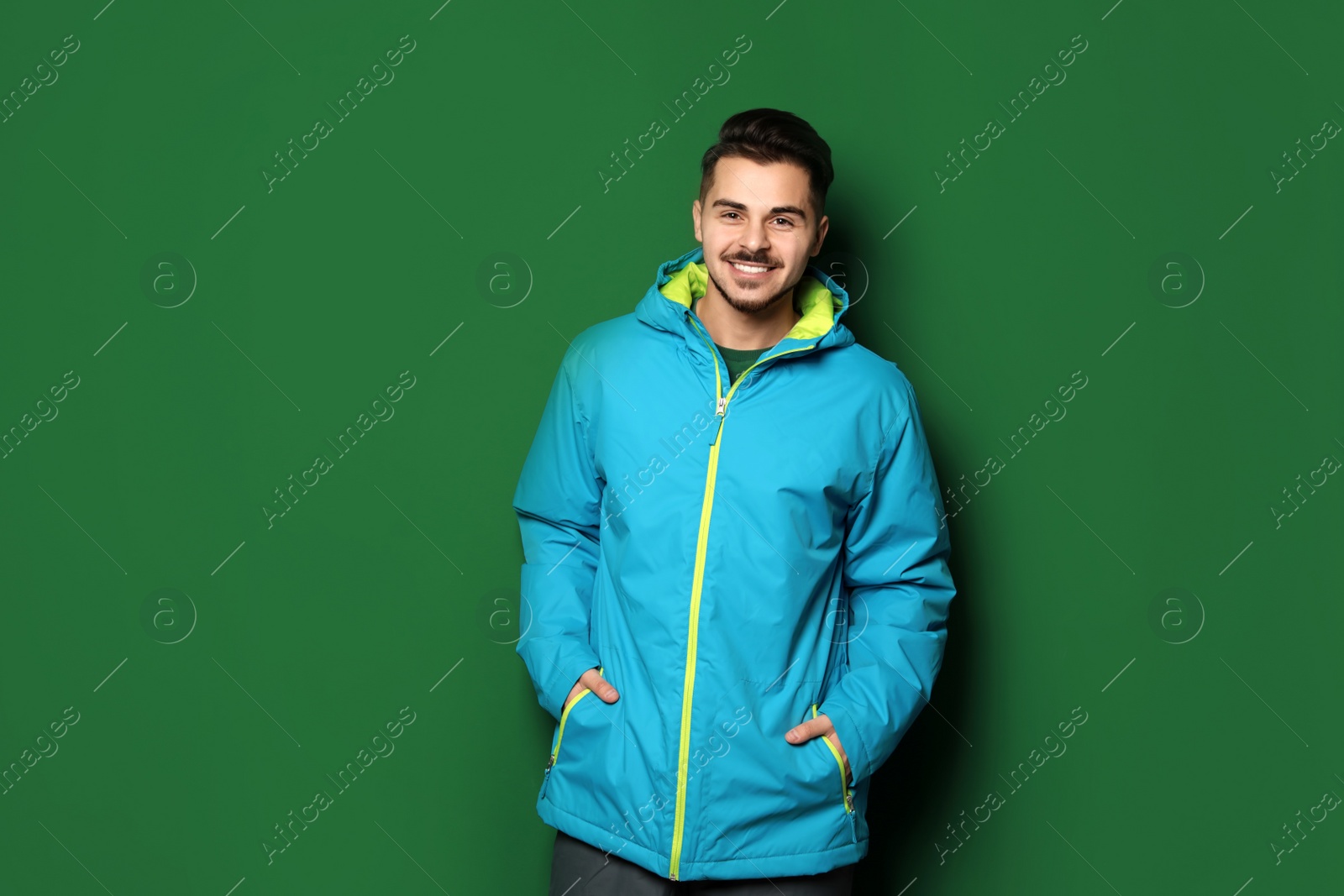 Photo of Young man wearing warm clothes on color background. Ready for winter vacation