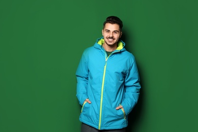 Photo of Young man wearing warm clothes on color background. Ready for winter vacation