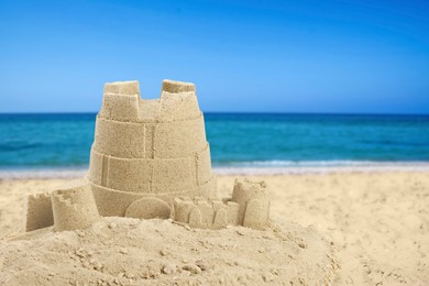Image of Sand castle on ocean beach, space for text. Outdoor play