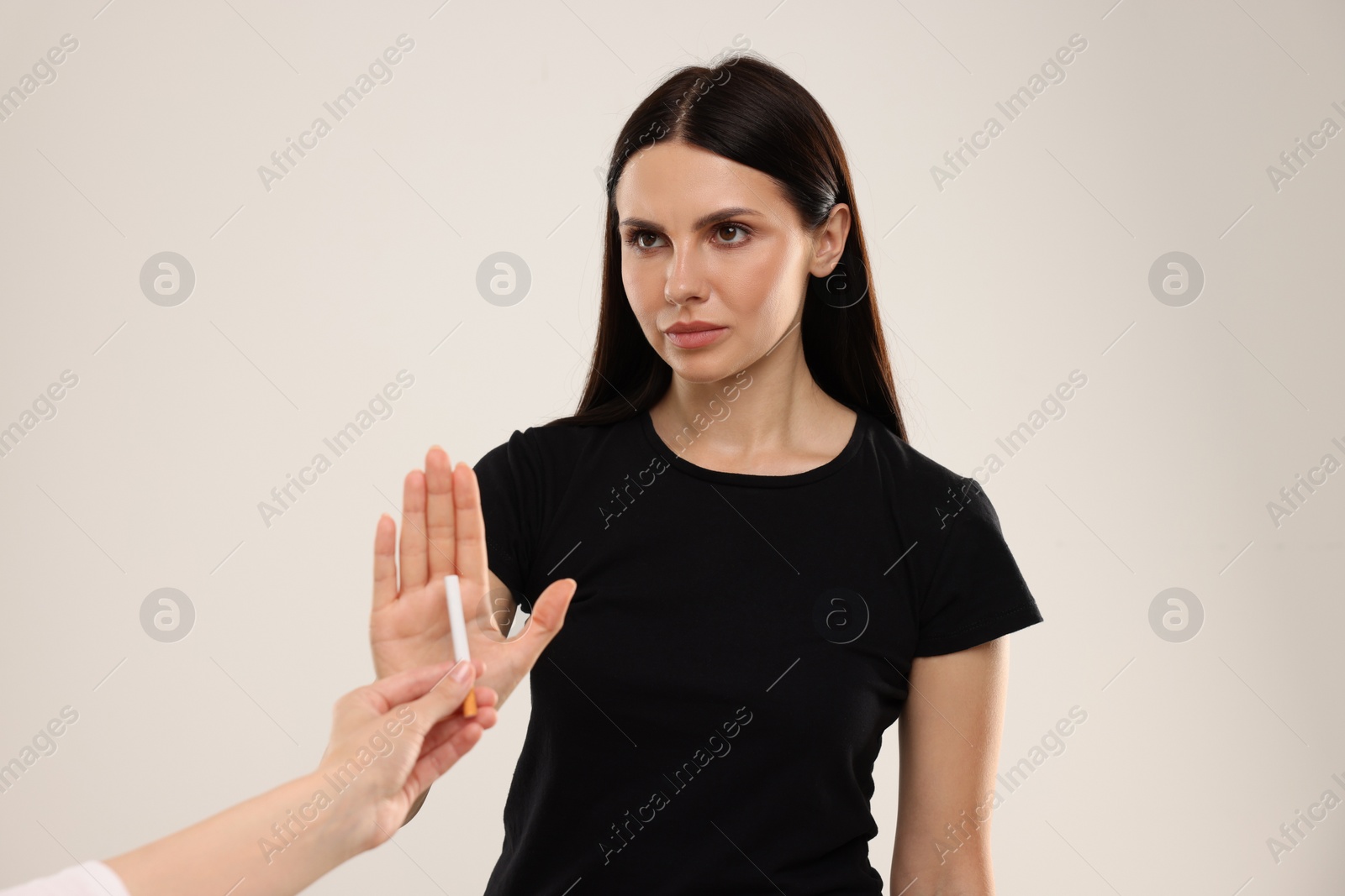Photo of Stop smoking concept. Woman refusing cigarette on beige background