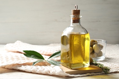 Bottle with fresh olive oil on table