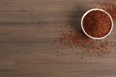 Dry rooibos leaves on wooden table, flat lay. Space for text