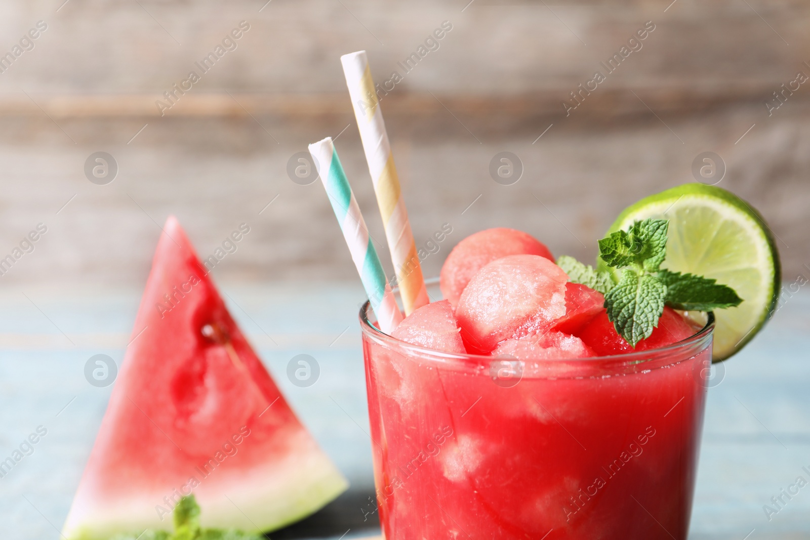 Photo of Summer watermelon drink with lime and mint on table, closeup