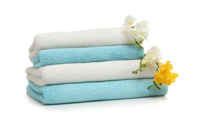 Photo of Stack of clean folded towels with flowers on white background