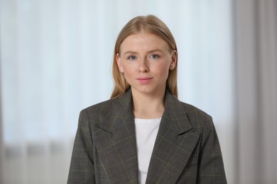 Portrait of beautiful young woman in stylish jacket indoors