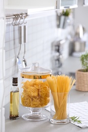 Photo of Raw pasta on light grey table in modern kitchen