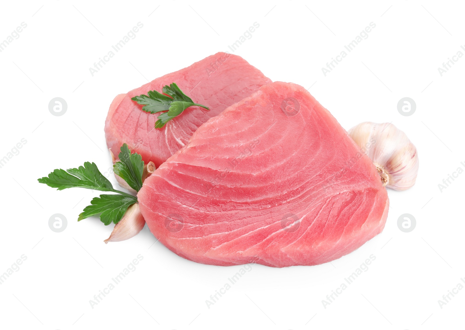 Photo of Fresh raw tuna fillets with parsley and garlic on white background