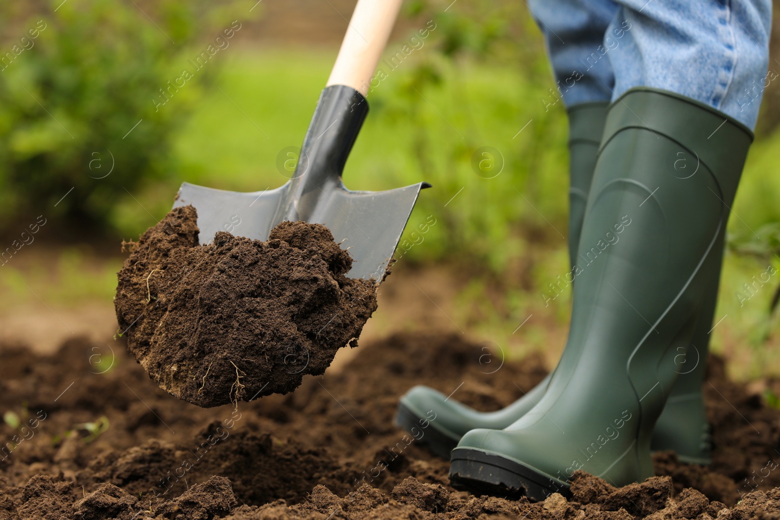 Photo of Worker digging soil with shovel outdoors, closeup. Gardening tool