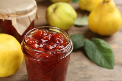 Delicious quince jam in jar on table, closeup