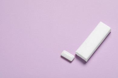 Photo of Pack of tasty chewing gums on lilac background, above view. Space for text