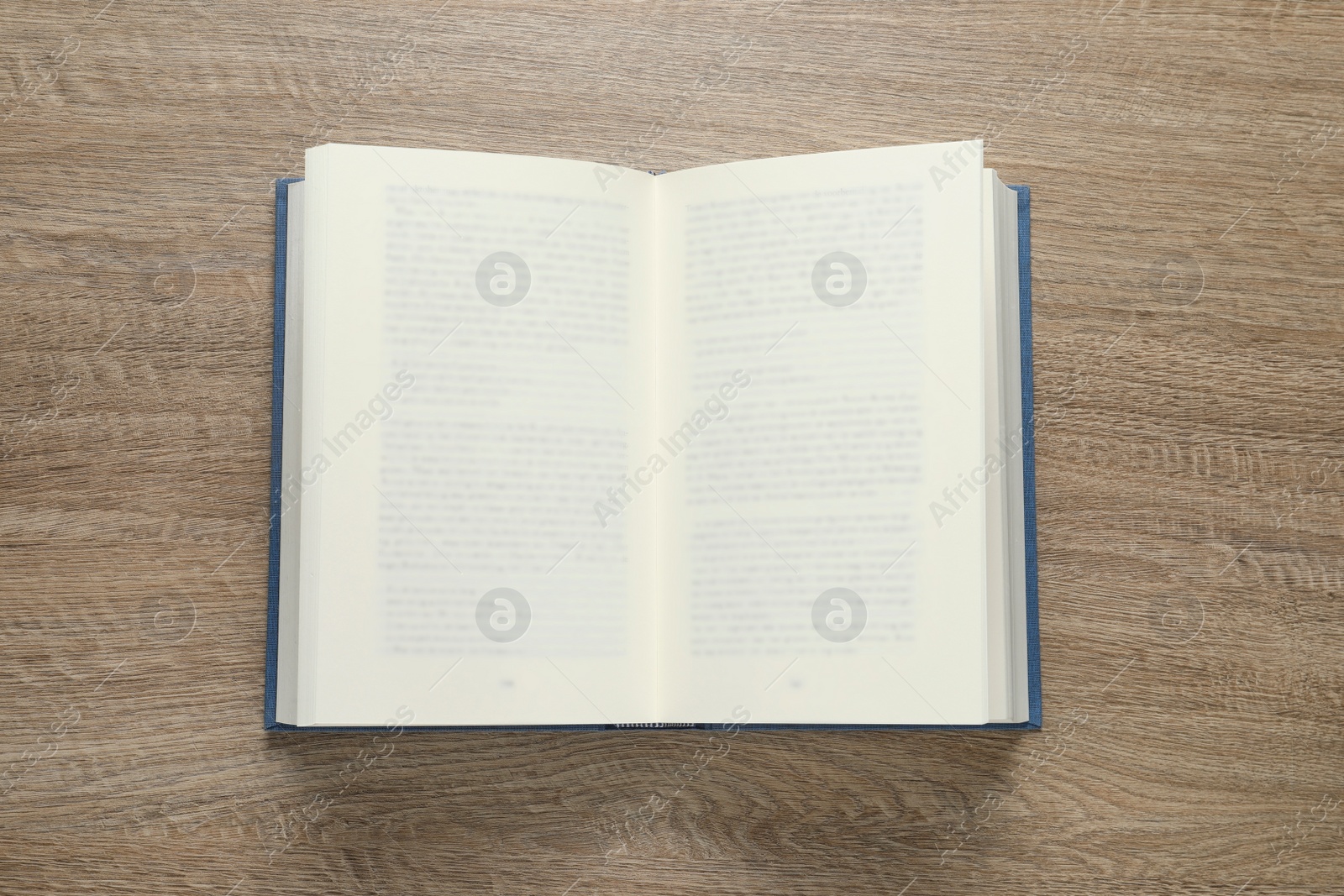 Photo of Open book on wooden table, top view