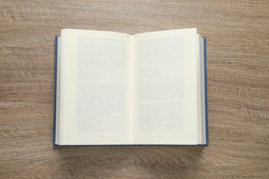 Photo of Open book on wooden table, top view