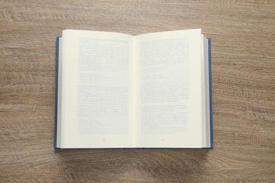 Open book on wooden table, top view