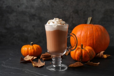 Photo of Delicious pumpkin latte on black slate table