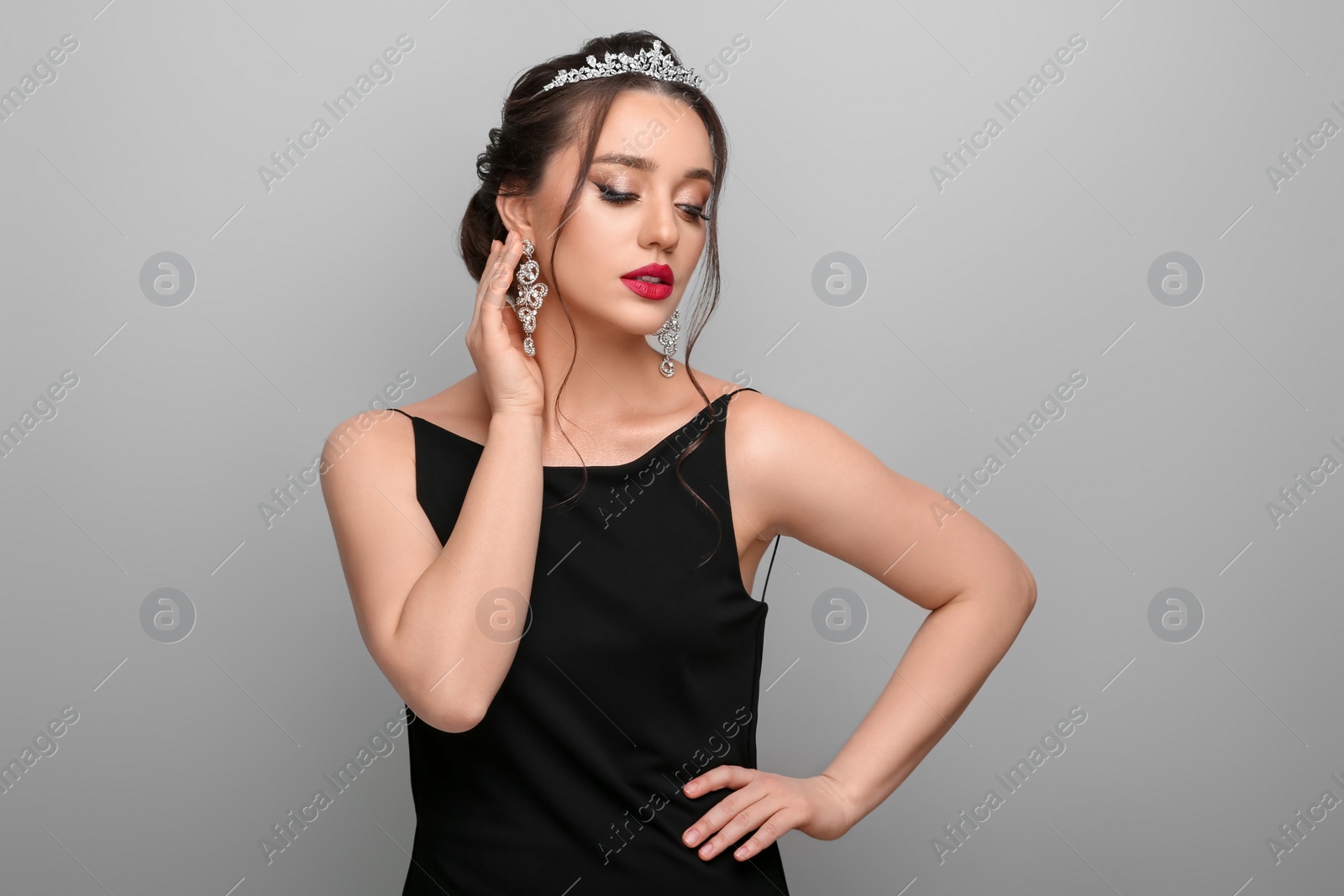 Photo of Beautiful young woman wearing luxurious tiara on light grey background