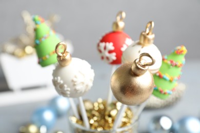 Photo of Delicious Christmas themed cake pops on blurred  background, closeup