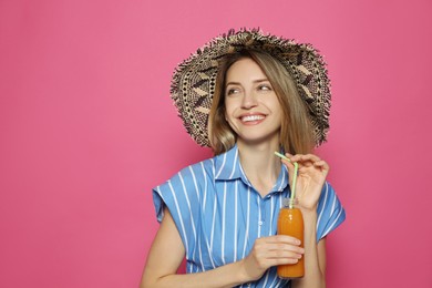 Beautiful young woman with straw hat and refreshing drink on crimson background, space for text. Stylish headdress